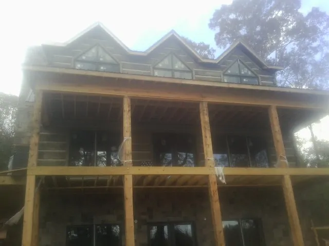 Dormers and porch framing on a large log home under construction — Roof Coating work by our crew in Gales Creek