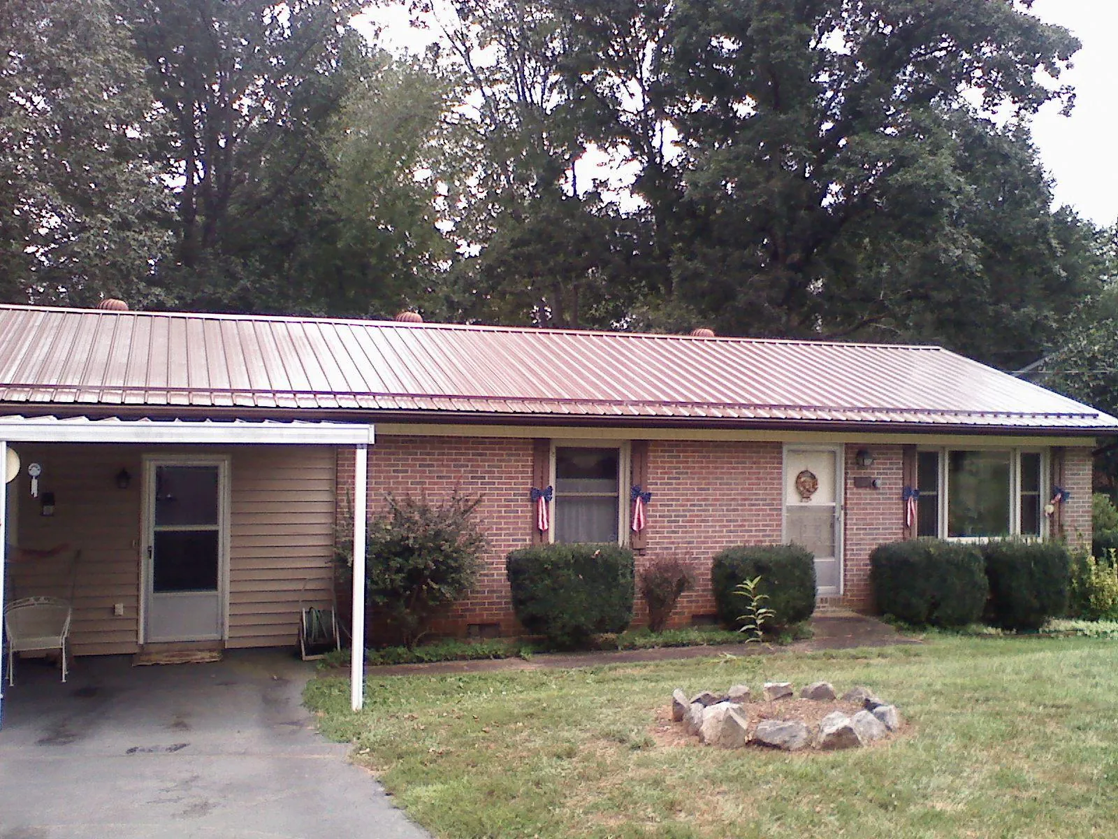 Bronze metal roof and carport on a brick ranch home — Roof Repair work by our crew in Gales Creek